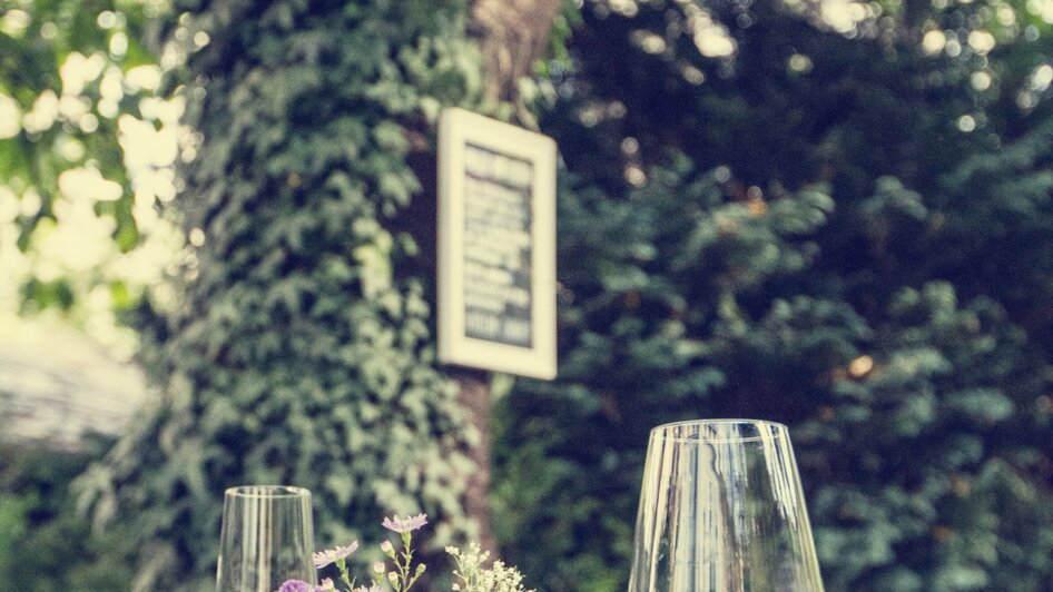 Ein stimmungsvolles Café mit Blumen und Gläsern auf einem Tisch.