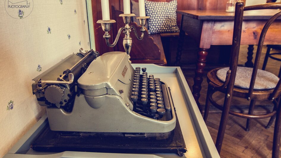 Eine vintage Schreibmaschine auf einem Tisch in einem gemütlichen Café.