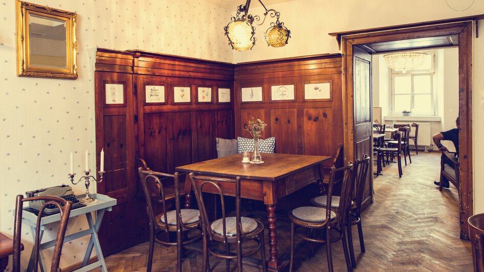 Gemütlicher Essbereich mit Holzstühlen und Tisch im Café.