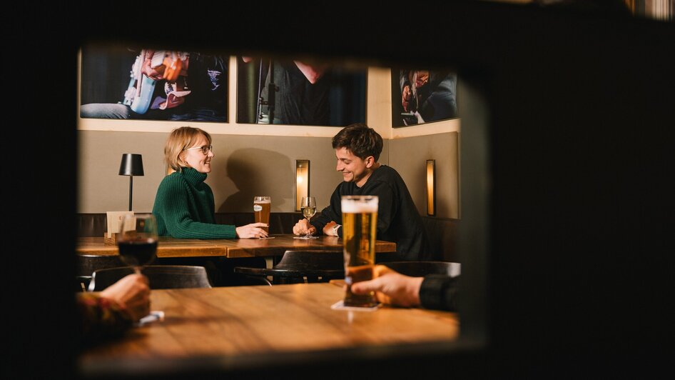 Paar an einem Tisch im Café Stockwerk mit Bier und Wein.