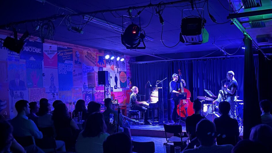 Jazzband spielt live in einer Bar, Publikum genießt die Musik.