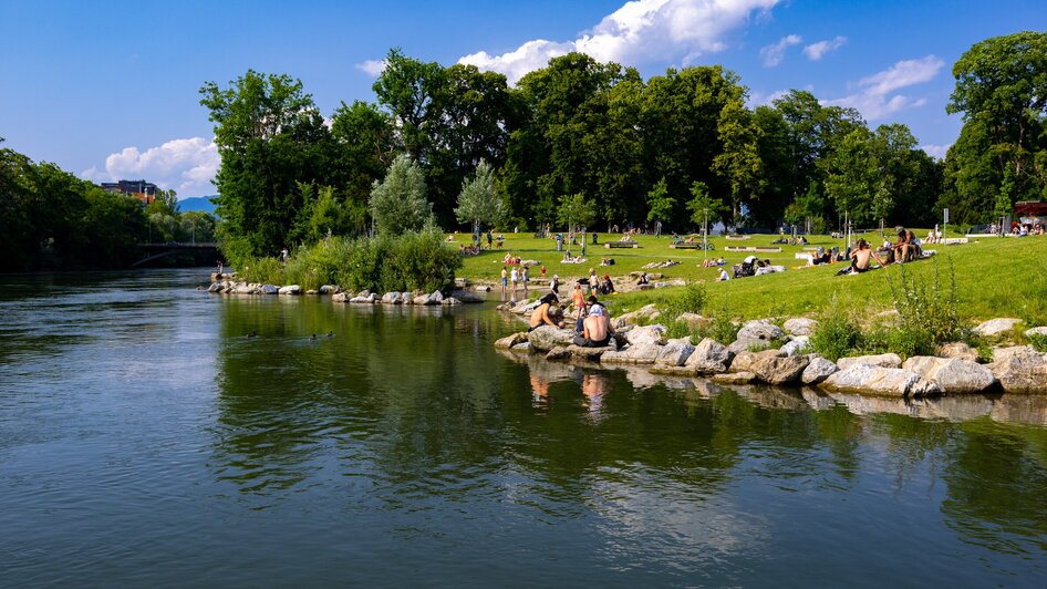 Entspannung am Mur-Ufer in Graz mit Badegästen und Grünflächen. | © Harry Schiffer