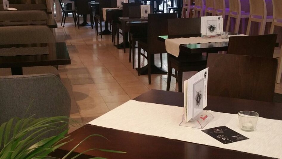 Ein moderner Restaurantbereich mit Tischen und Stühlen.
