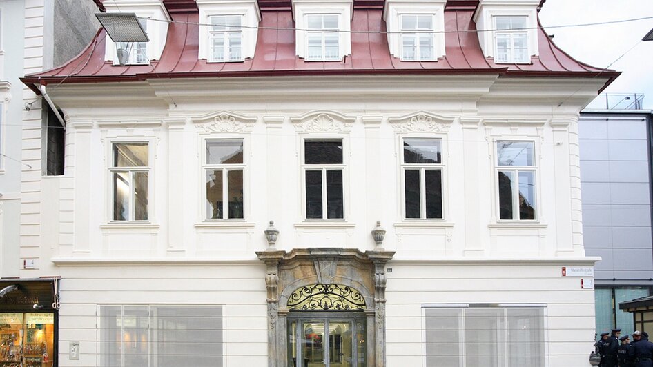 Historisches Gebäude mit rotem Dach und eleganter Fassade in Graz. | © J.J. Kucek