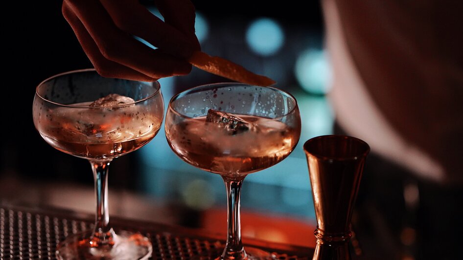 Zwei Cocktails mit Eis und Zitronenschale in einer Bar.