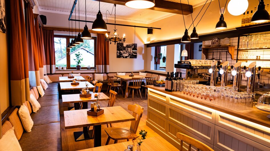 Gemütliches Restaurant mit Holzstühlen und beleuchtetem Tresen.