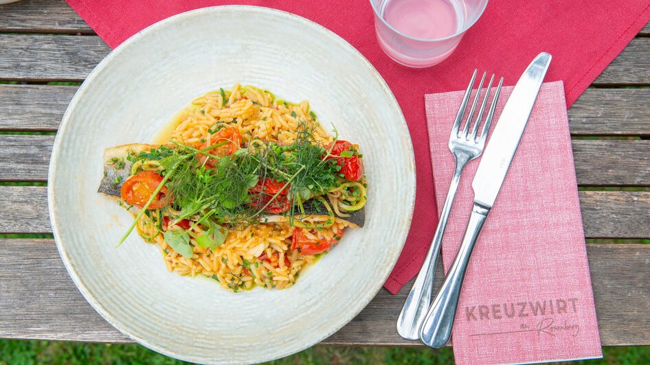Ein Teller mit Fisch, Tomaten und Pasta im Kreuzwirt am Rosenberg in Graz.