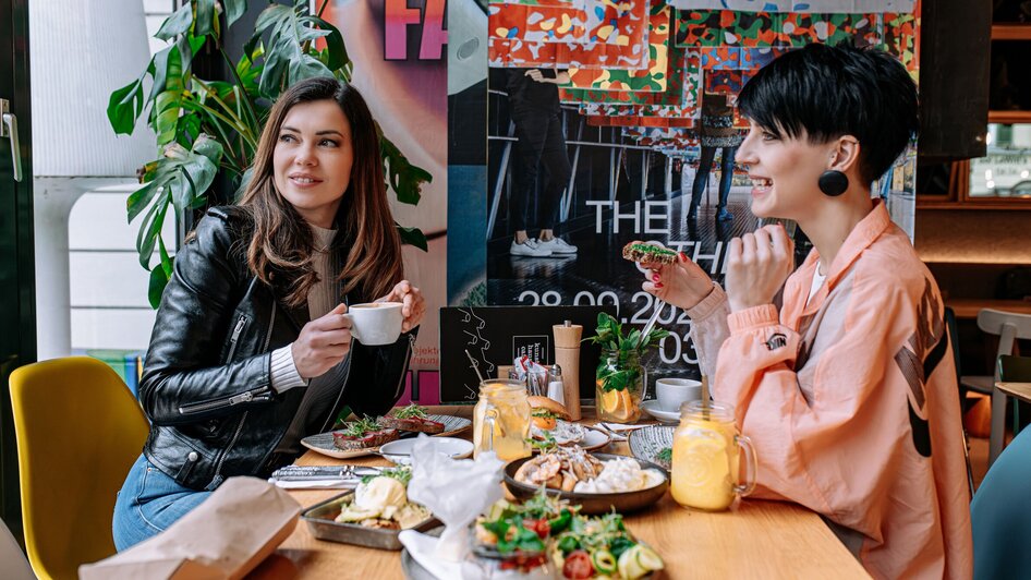 Zwei Frauen im Kunsthauscafé in Graz beim Essen und Trinken.
