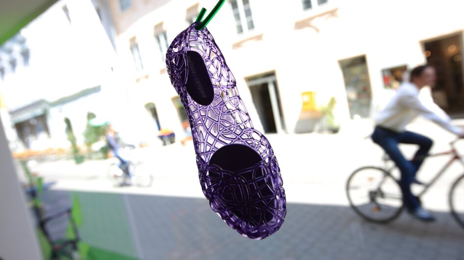 Ein lila Schuh hängt an einer Schnur im Schaufenster in Graz. | © Graz Tourismus - Harry Schiffer