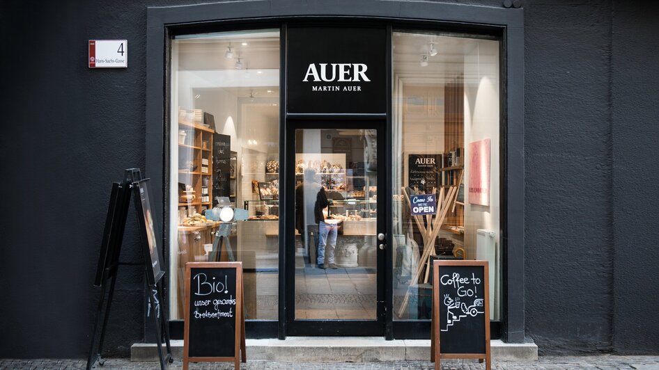 Außenansicht der Bäckerei Martin Auer in Graz mit zwei Tafeln vor dem Eingangsbereich.