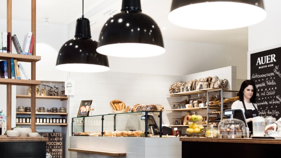 Gemütliches Café mit einem Kinder-Bereich mit Spielzeug und Backwaren in einer Vitrine.