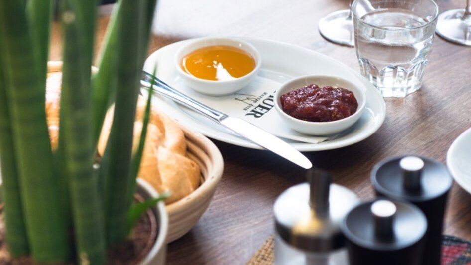 Ein Tisch mit Essen, Getränken und Pflanzen bei MARTIN AUER.