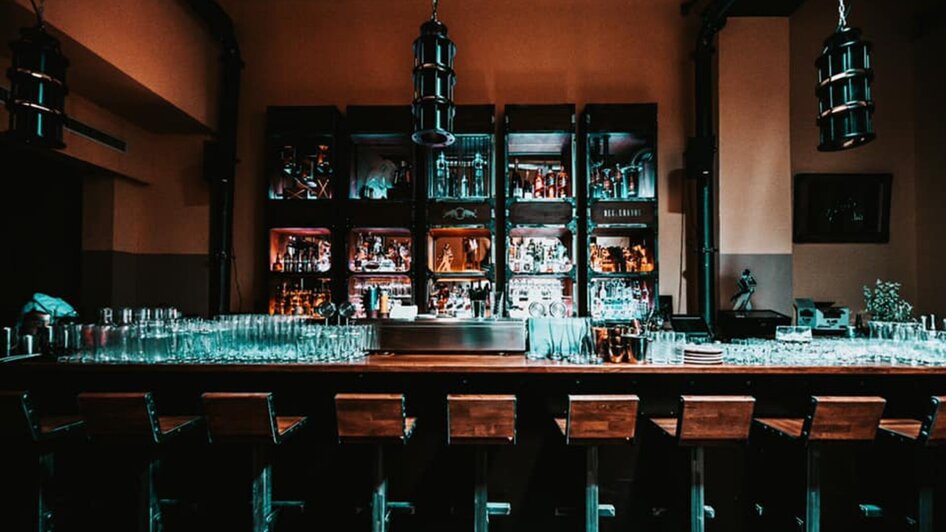 Stylische Bar mit Glasregalen und einer langen Theke. | © Mordial