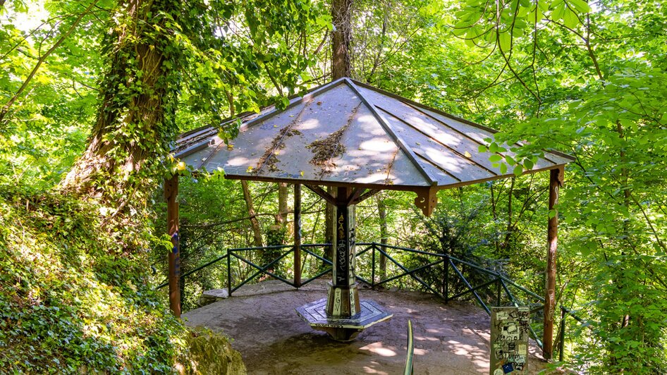 Ein Pavillon umgeben von Bäumen und Grünpflanzen im Park.