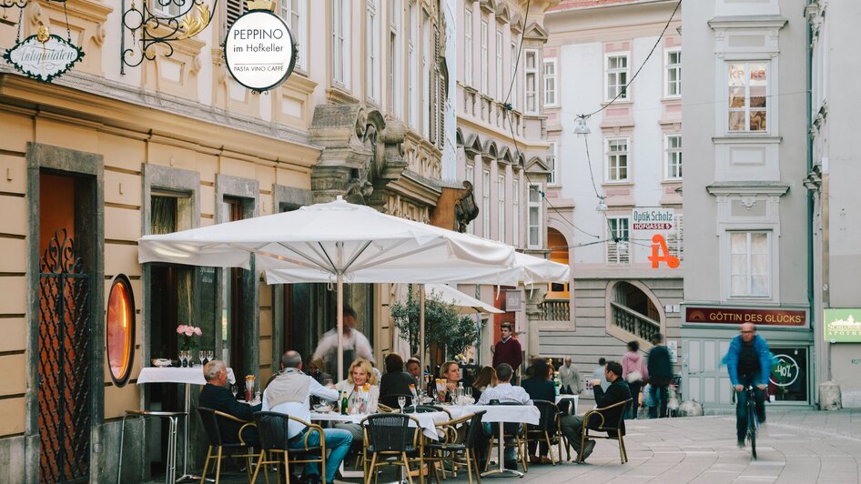 Gäste essen draußen bei Peppino im Hofkeller in Graz.