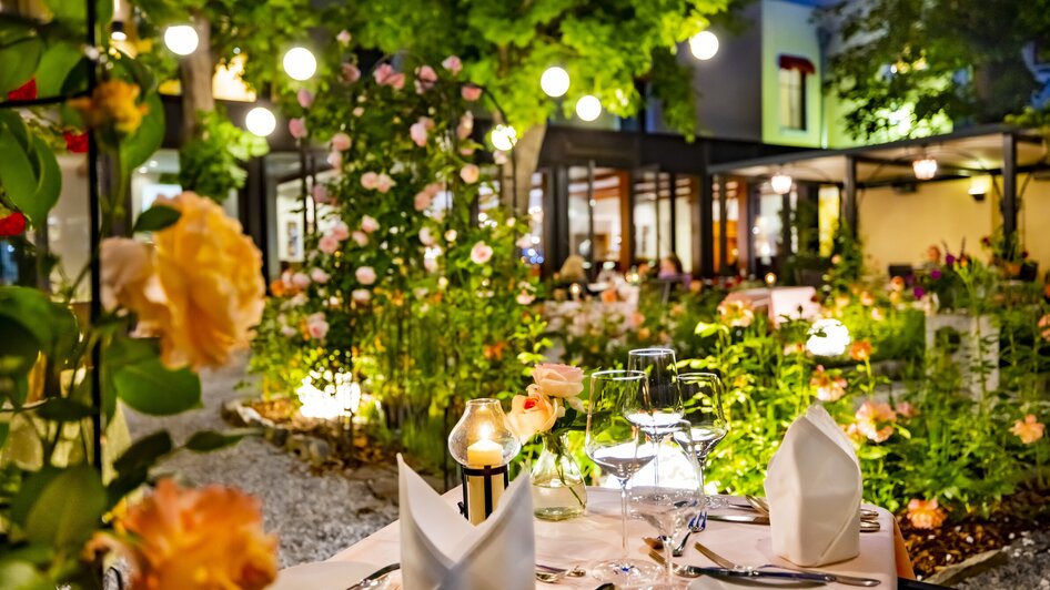 Gemütliches Restaurant im Freien, schön beleuchtet mit Rosen und Kerzen. | © Florian im Parkhotel