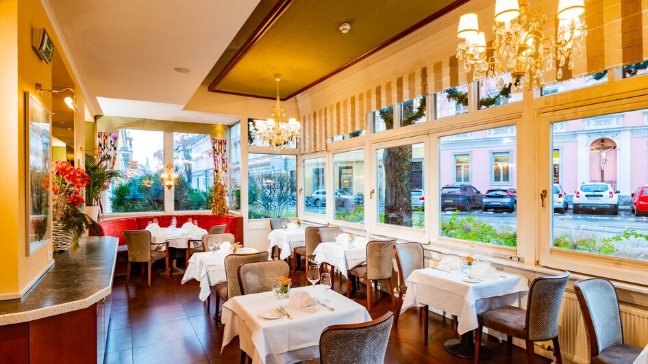 Elegantes Restaurant mit Blick auf den Garten, Tische mit weißen Tischtüchern, gemütliche Atmosphäre. | © Parkhotel
