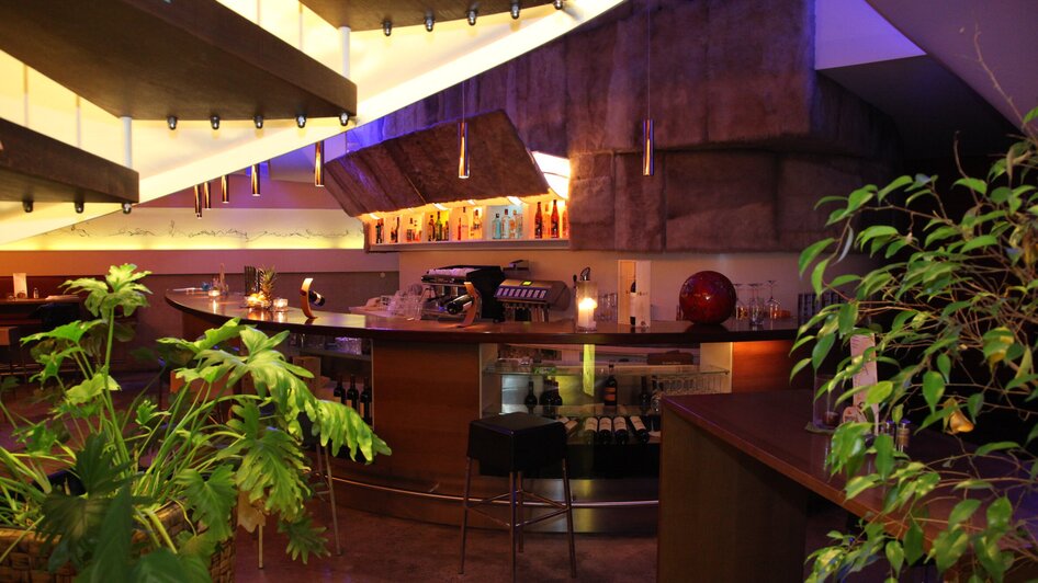 Stylische Bar im Restaurant Rondo mit Pflanzen und Beleuchtung.