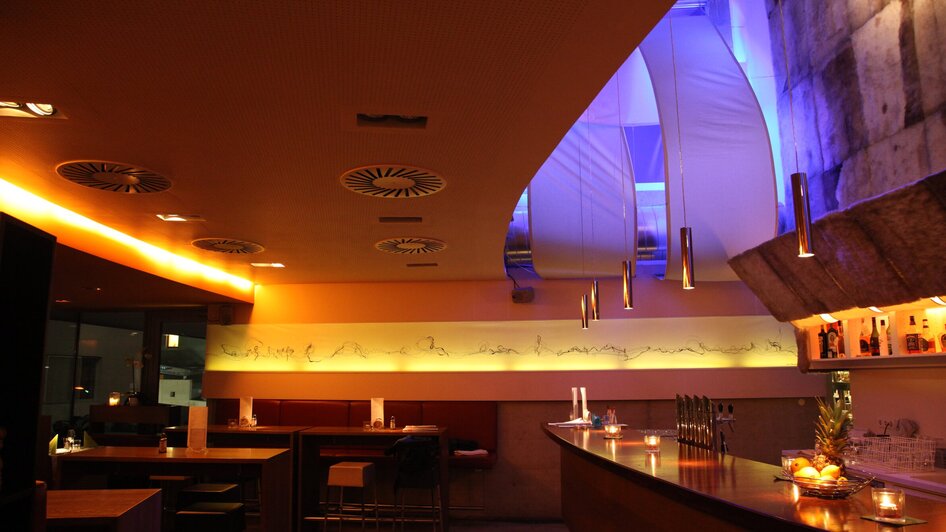 Modernes Restaurant mit einer stilvollen Bar und gedämpfter Beleuchtung.