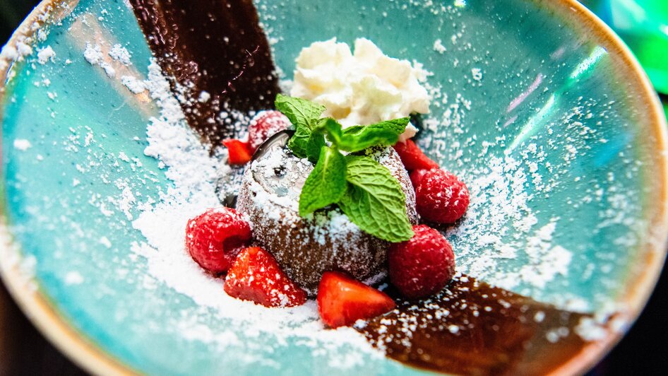 Delikate Schokoladentorte mit Beeren und Sahne in einer bunten Schüssel.
