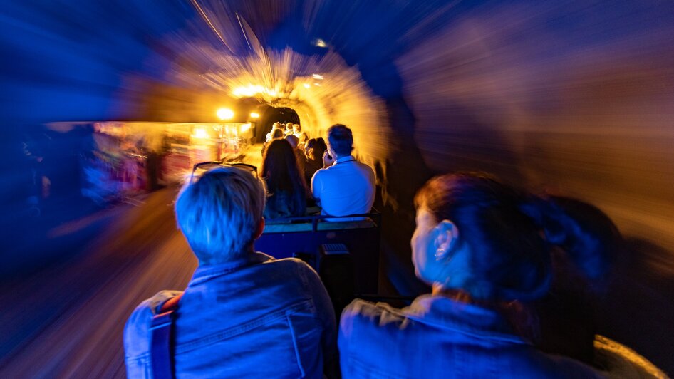 Fahrt mit der Grazer Märchenbahn durch einen bunten Tunnel.