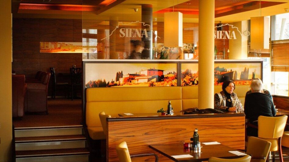 Gemütliche Atmosphäre in der Trattoria Siena mit Gästen.