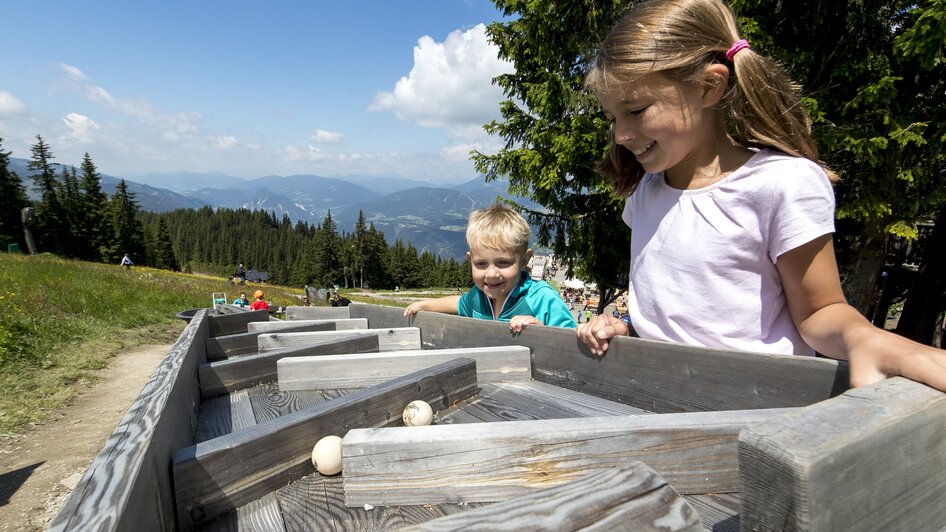 Kinder spielen mit Kugelbahn im Hopsiland