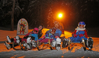 Familie auf Schlitten.  | © Hans-Peter Steiner